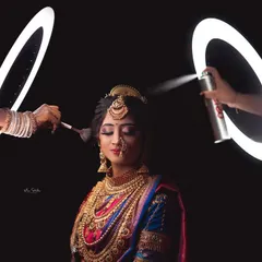A stylized shot capturing the final touches of the bridal preparation. The use of ring lights to frame the makeup brush and hairspray adds a creative and modern twist to a classic getting-ready photo.
