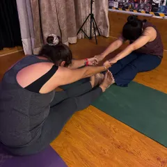 A perfect day for us includes dim lights, a good stretch, and seeing our members progress. Here I am assisting a student with a partner stretch.