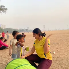 A coach takes a moment to connect with a young participant. We ensure every child feels seen and encouraged, creating a positive and inclusive atmosphere at our beach events.