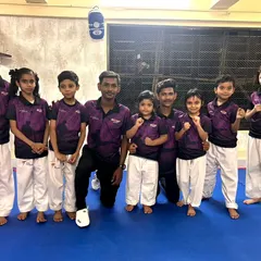 Our team, united and strong. Coaches and students pose together in our academy's official t-shirts, representing the Fit and Fight family.