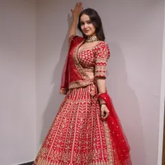 The quintessential red bridal lehenga, but with my signature touch. The intricate gold embroidery covers every inch, creating a look that is both timeless and breathtakingly beautiful.