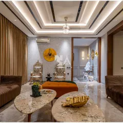 A different perspective of the drawing room, showcasing the layered ceiling with concealed lighting and the elegant flow into the adjacent dining area. The silver throne-like chairs add a touch of regal charm and personality.