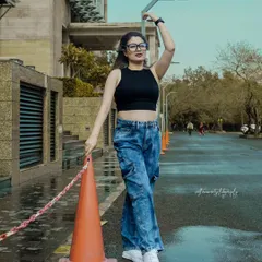 This shot for a denim brand uses an everyday traffic cone as a prop to add a pop of color and an element of spontaneous street style. The pose is confident and relaxed, capturing the brand's youthful energy.