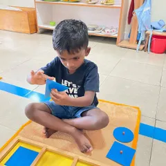 Working with the geometric insets from the cabinet, this child is developing a muscular memory of each shape. This tactile exploration is a key part of how we move from concrete understanding to abstract thought in geometry.