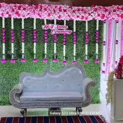 A beautiful and elegant setup for a Half Saree Ceremony. We used a lush green grass wall backdrop, accented with pink and white artificial flower garlands and elegant white furniture to create a fresh, traditional look.