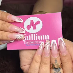 A close-up of these stunning V-cut French tip bridal nails. The combination of a sharp white tip and delicate glitter is perfect for a modern bride. I love holding up my business card to show off a fresh set.