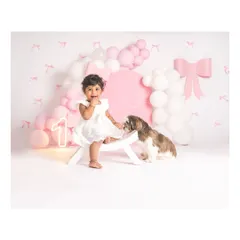 A paw-fect friendship in the making. This behind-the-scenes shot captures a sweet moment between a baby girl and her furry sibling during a first birthday shoot.