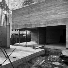 The raw, board-formed concrete walls of the Moradabad villa project. The texture of the wooden planks used for the formwork is permanently imprinted on the concrete surface.