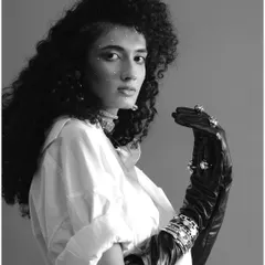 A classic black and white portrait from a FAD International shoot. The model's expressive gaze, voluminous hair, and embellished glove create a timeless and elegant fashion image.