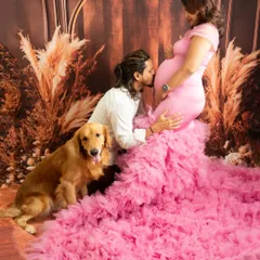 A glamorous maternity portrait featuring a flowing pink gown. I welcome partners and beloved pets to be part of the session, as they are an important part of your growing family's story. This shot captures the anticipation and love surrounding the new arrival.