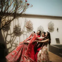 A candid and joyful moment between the bride and her bridesmaids. Their playful interaction and genuine laughter make for a heartwarming and authentic memory.