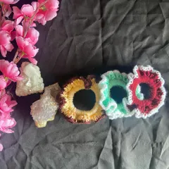 This image shows the scrunchies lined up, highlighting the detailed crochet work on the ruffled edges. These are a great way to add a pop of custom color to your hairstyle.