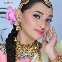 A beautiful portrait of the South Indian bride, highlighting the temple jewelry, the bright pink lip, and the traditional bindi.
