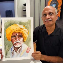 This student is holding up his wonderfully detailed watercolor portrait of a man in a yellow turban, a piece he completed in one of my guided painting sessions.
