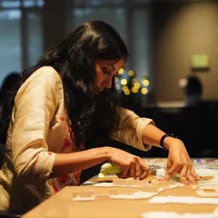 An architect in our studio carefully works on a physical model. Model making is an essential part of our process, allowing us to test spatial relationships, scale, and form in three dimensions.