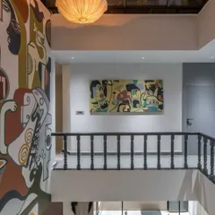 Another perspective of the 'House of the Rising Sun' mural, showing its relationship with a complementary canvas piece on the adjacent wall. We often create multiple artworks within a space to build a cohesive visual story.