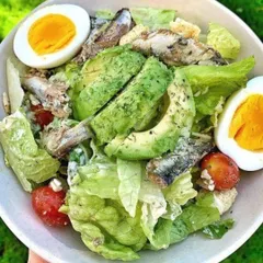 A nutritious and protein-packed salad. This dish combines fresh greens with avocado, hard-boiled eggs, cherry tomatoes, and sardines, all tossed in a light and creamy dressing.
