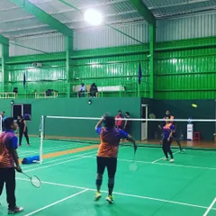 An employee prepares to return a shot during a competitive doubles match. My facility is perfect for capturing the dynamic action of a fast-paced corporate sports day.