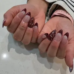 Another view of our maroon and glitter French design, showing how the light catches the sparkling accent nail.