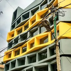 A commercial project under construction in Indiranagar, featuring a parametric facade design. The interplay of grey and yellow geometric forms creates a dynamic and modern exterior for this office building.