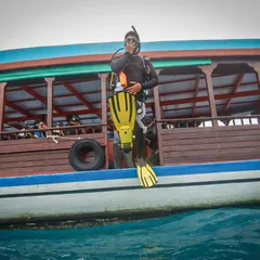 Taking the giant leap. A diver begins their descent into the warm, clear waters of Gaafaru. This is the moment the adventure truly begins.