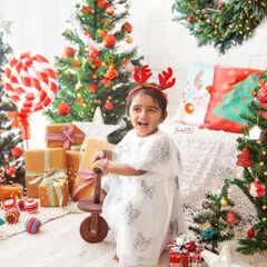 Full of festive cheer. This little girl is having a wonderful time playing in my Christmas setup, complete with trees, gifts, and a fun rocking horse.