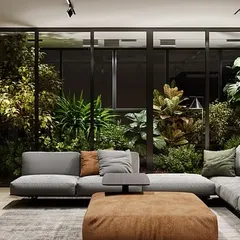 We transformed this living room by installing a floor-to-ceiling glass-enclosed garden. This lush installation acts as a living wall, providing a constant view of vibrant greenery while separating the space with style.