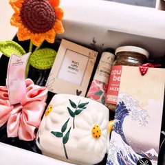Sending some sunshine for her birthday! This hamper features a crochet sunflower, a daisy-themed mug, a 'smells like sunshine' candle, and other cheerful goodies.