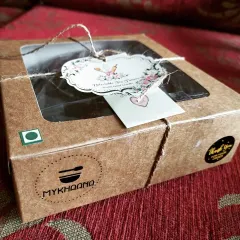 Our treats are packed with a personal touch. This rustic cardboard box, tied with twine and a custom tag, holds our delicious home-baked biscotti, ensuring they arrive fresh and full of love.