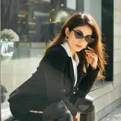 A street style portrait using a shop window for reflections and depth. This shot captures a chic, urban look, blending fashion with the surrounding environment for a candid, magazine-style feel.