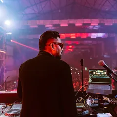 A shot from behind the decks, looking out at a massive audience. This perspective shows the scale of the events I play, where my music connects with thousands at once.