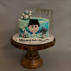 This "workaholic" cake was made for a superhero dad. It features a fondant caricature juggling a phone and laptop, surrounded by his favorite things.