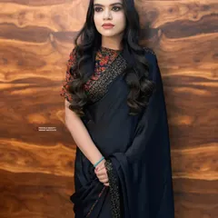 Timeless elegance in a black saree. The hair is styled in classic, soft waves that add a touch of glamour without overpowering the simplicity of the look. Perfect for a formal dinner or reception.