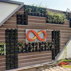 This photo shows the installation process of a commercial green wall with a custom logo. I handle the entire setup, from the backing panel to placing each plant.