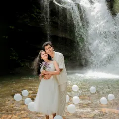 A dreamy and romantic waterfall shoot, with white balloons floating on the water. Adding simple props can transform a location and create a magical atmosphere.