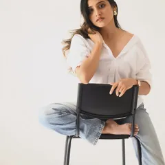 A full-length seated pose that feels relaxed and confident. This is a great example of a simple, effective portfolio shot.