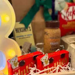A close-up of the indulgent treats, including Hershey's, Nutties, and frappe cold coffee, because love is best expressed through little joys.
