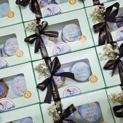 Elegant return favors for a New Year's celebration. Each box contains two customized cupcakes, tied with a branded ribbon and a touch of baby's breath for a sophisticated finish.