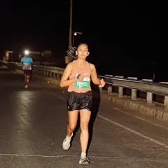 Focused and determined on a dark road during an ultra marathon. My coaching prepares you for the mental and physical challenges of running for hours on end.