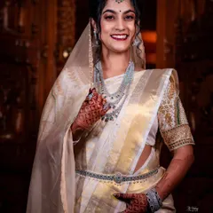 For her reception, this Iyer bride chose a stunning off-white and gold saree draped in a Kannadiga style. The addition of a sheer veil and diamond jewelry created a look of modern royalty.