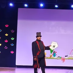 Performing a jumbo card trick on stage. These large cards are great for bigger audiences, making sure no one misses the magic.
