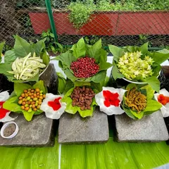 A beautiful spread of nostalgic Indian treats, naturally displayed on banana leaves and stone slabs. It's a rustic and authentic presentation that guests love.