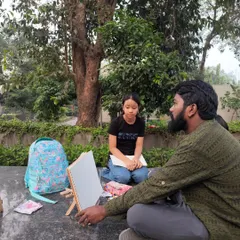 An instructor giving guidance during our outdoor art session. We believe in creating a relaxed environment where everyone can learn at their own pace.