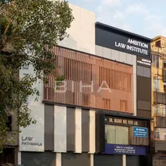 The finished facade for the Ambition Law Institute, viewed from the street. The design juxtaposes white and black ACP sheets with warm metal louvers to create visual interest and a sense of refined order.