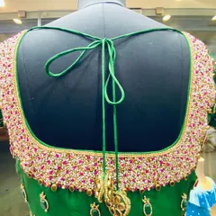For a truly grand look, I do full-coverage bead and stone work. This green bridal blouse has a heavy, hand-embroidered back with thousands of beads, all stitched securely for a perfect finish. The matching latkans complete the design.