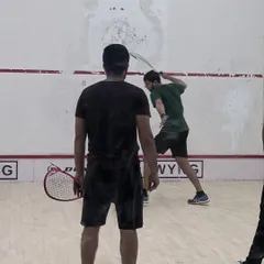 A player executes a powerful backhand shot during a practice rally. Our coaching helps players develop a full range of shots to control the game.