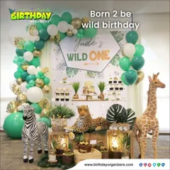 Take a walk on the wild side with our "Wild One" jungle safari theme. This elegant setup combines a green and gold balloon arch with lifelike animal props like a zebra and giraffe, creating a sophisticated yet fun atmosphere for a first birthday.