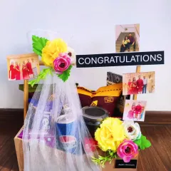 This congratulations hamper shows that a smaller gift can still make a big impact. It includes snacks, a drink, and is beautifully decorated with flowers, tulle, and personal photos.