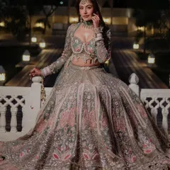 A full-length shot of the pastel green and pink Bindani couture lehenga. The grand setting and the outfit's flare create a truly royal bridal look.