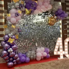 A glamorous photo booth for a 40th anniversary, featuring a silver sequin shimmer wall. These walls catch the light beautifully and provide a stunning, sparkling background for pictures.